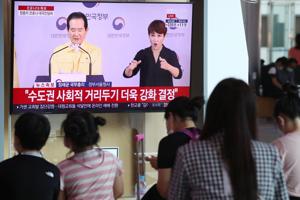 18일 오후 서울역 대합실에서 시민들이 정세균 국무총리 코로나19방역 강화 관련 대국민 담화 발표를 시청하고 있다.  사진 연합뉴스