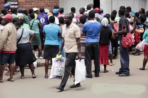 지난 2월 짐바브웨 하라레에서 주식인 옥수숫가루 백을 들고 가고 있는 남성. 남부 아프리카는 지난 수년간 논스톱으로 기후변화의 충격에 직면한 곳이다. EPA=연합뉴스