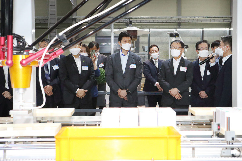 KT 구현모(오른쪽 앞 줄 세 번째) 대표, 현대중공업지주 정기선(오쪽 앞 줄 네 번째) 부사장 등 KT-현대중공업그룹 관계자들이 자동화 솔루션이 적용된 스마트팩토리 시연을 보고 있다. 사진=KT