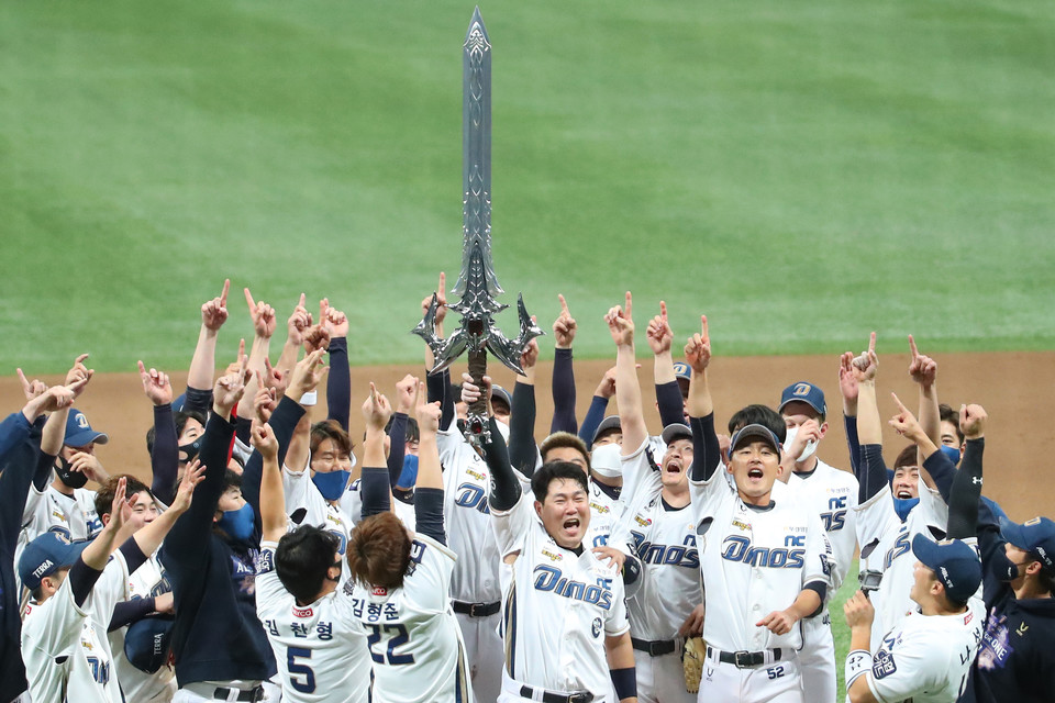 우승을 차지한 NC 다이노스 양의지 등 선수들이 그라운드에서 모기업 NC소프트의 온라인게임 리니지의 집행검을 들어 올리며 승리를 자축하고 있다. 연합뉴스