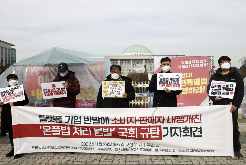 지난 11월 29일 국회 앞에서 민변 민생경제위원회 등의 주최로 열린 ‘온플법 처리 불발 국회 규탄 기자회견’에서 참석자들이 온라인 플랫폼 공정화법 처리 등을 촉구하는 내용의 피켓을 들고 있다. [사진=연합뉴스]