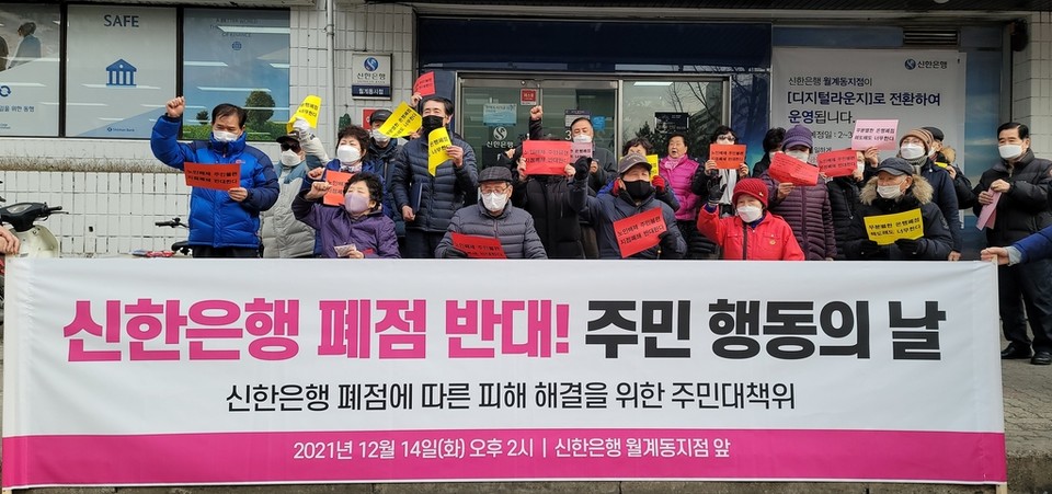 14일 오후 신한은행 월계동지점 앞에 모여 폐점반대 구호를 외치는 주민들[사진=연합뉴스]