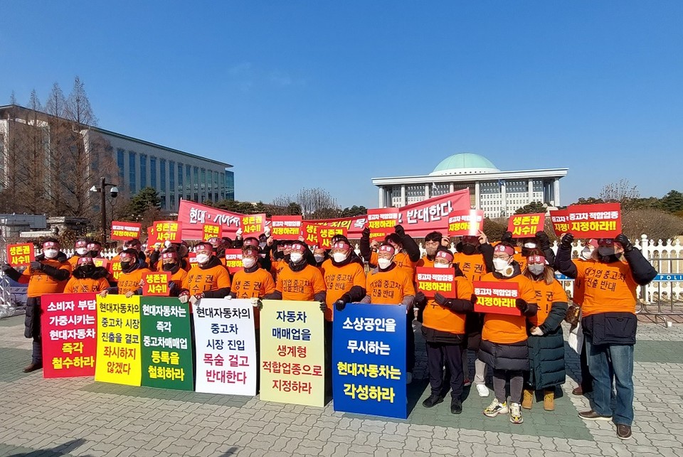 한국매매연합회 회원들이 지난 25일 국회 앞에서 현대기아차 중고차시장 진출을 반대하는 내용의 현수막을 들고 규탄대회를 개최했다. [사진=한국매매연합회]