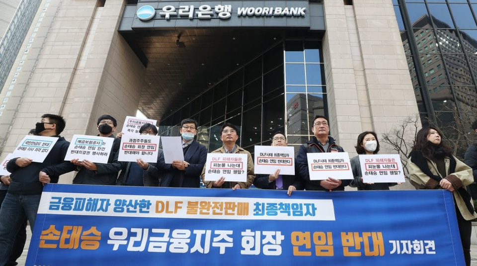 2020년 3월 25일 오전 서울 중구 우리은행 본점 앞에서 열린 ‘금융피해자 양산한 DLF 불완전판매 최종책임자 손태승 우리금융 회장 연임 반대 기자회견’에서 참석자들이 손팻말을 들고 있다. [사진=연합뉴스]