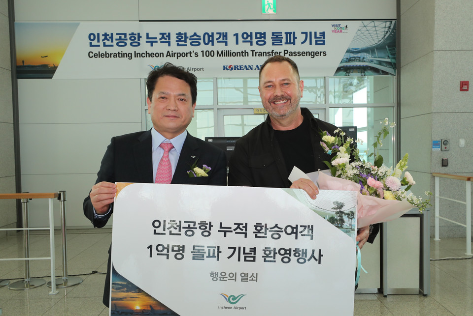 지난 2일 오후 인천공항 제2여객터미널 232번 게이트 앞에서 열린 ‘인천공항 누적 환승여객 1억명 돌파 기념행사’에서 인천국제공항공사 김경욱 사장(사진 왼쪽)이 1억 번째 환승객(사진 오른쪽)에게 행운의 열쇠를 증정하고 함께 기념촬영을 가졌다. [사진=인천국제공항공사]