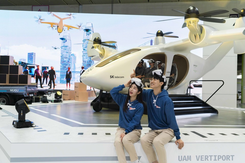 실물 사이즈의 UAM 모형 기체와 가상 체험 시뮬레이터를 결합한 UAM(Urban Air Mobility) 가상 체험 시뮬레이터 공간에서 관람객들은 VR 기기를 착용하고 시뮬레이터에 탑승해 2030년의 서울과 부산을 비행하며 연계교통·배터리 충전·인포테인먼트 등 서비스를 생생하게 경험할 수 있다. [사진=SK텔레콤]