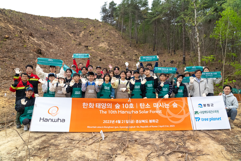 태양의 숲 조성 부지 앞에서 단체 사진을 찍는 행사 참가자들 [사진=한화건설]