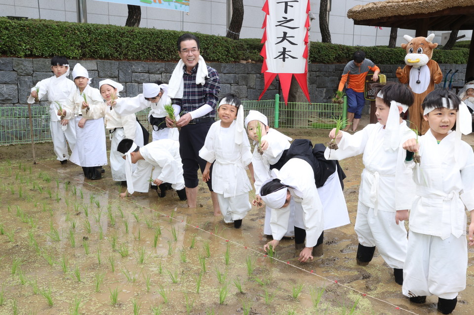 이성희 농협중앙회장이  22일 서울 중구 농업박물관 앞 야외농장에서 어린이들과 함께 전통 손모내기 체험행사에 참여했다. [사진=농협]