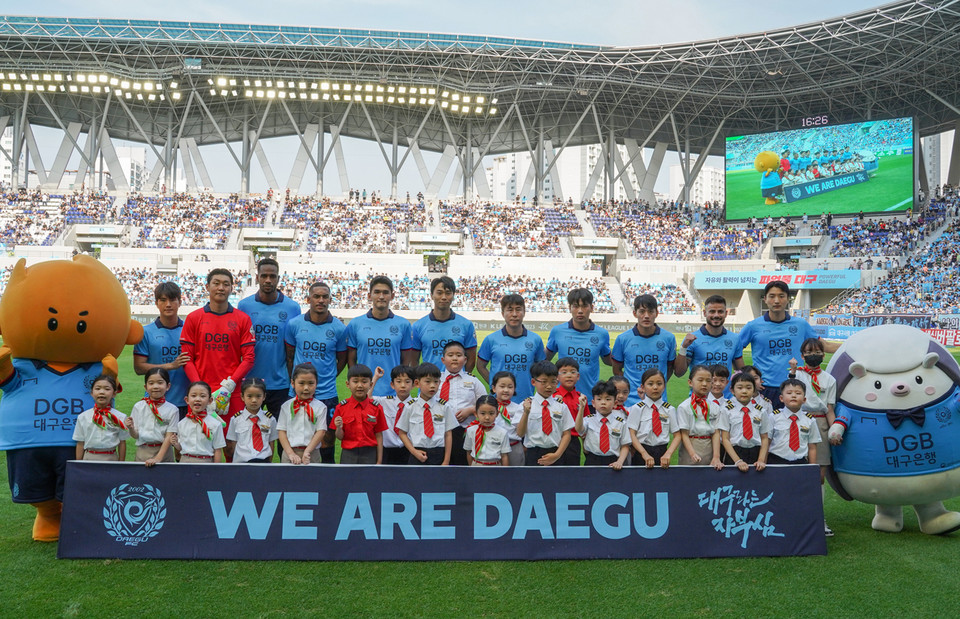 DGB대구은행파크에서 열린 대구FC 홈 경기에서 진행한 ‘티웨이항공 브랜드데이’에서 티웨이항공 유니폼을 입은 에스코트 키즈 어린이 서포터즈들이 선수들과 함께 기념 촬영을 하고 있다. [사진=티웨이항공]
