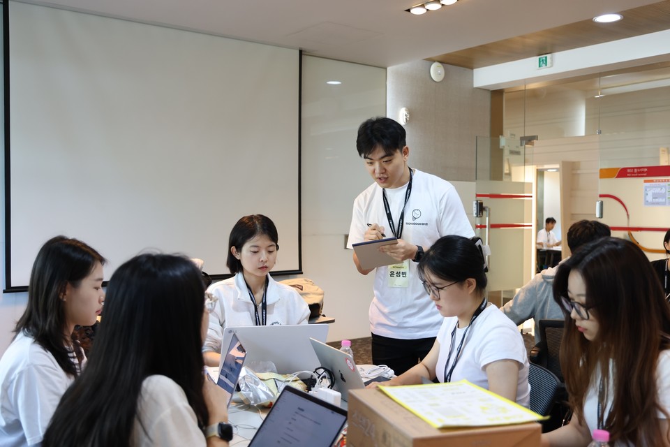 해커톤 현장에서 대학생들이 멘토와 함께 아이디어 회의를 하고 있다. [사진=SKT]