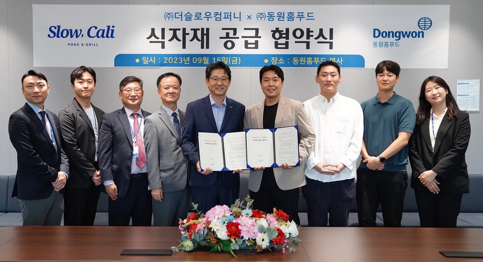 동원홈푸드와 더슬로우컴퍼니가 식자재 공급에 관한 업무협약을 체결했다. 왼쪽에서 5번째에 서있는 인물은 정문목 동원홈푸드 대표이며, 6번째에 서있는 인물은 전현제 더슬로우컴퍼니 대표다. [사진=동원홈푸드 제공]