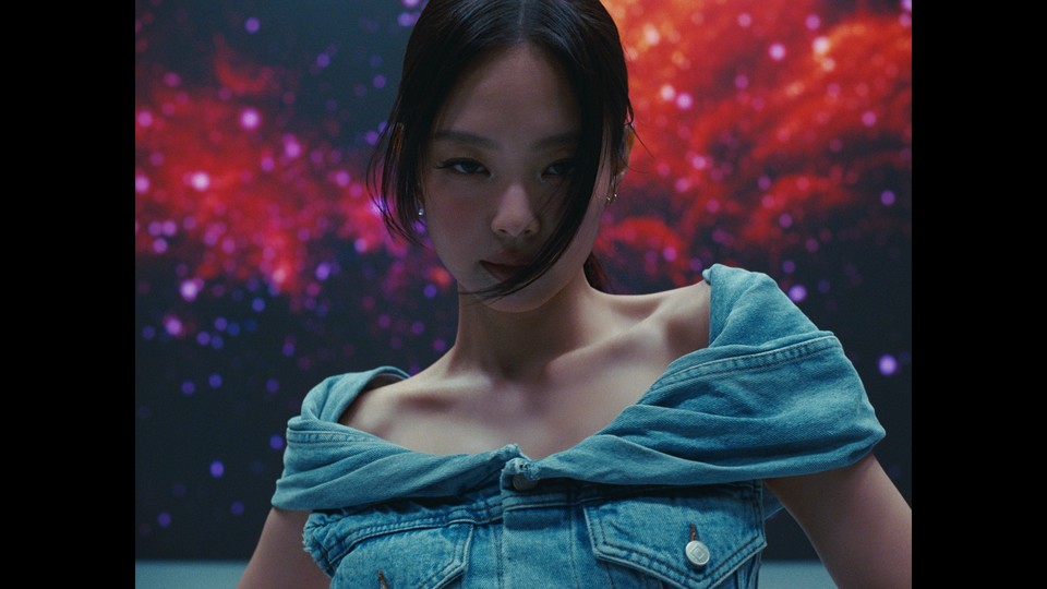 Jennie of BLACKPINK gazing directly at the camera with her signature expression, conveying intensity and quiet confidence