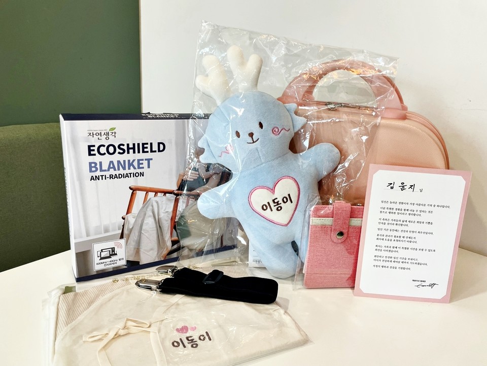 오스템임플란트가 임신한 직원에게 지급하는 임신축하선물세트.모성보호 표식으로 사내시설 이용 시 배려 받을 수 있드록 있도록 제작한 핑크색 사원증 케이스와 대표이사 자필서명 축하카드 등으로 구성돼있다.