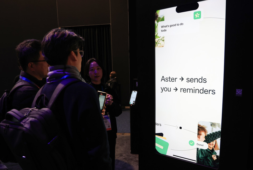 CES 2025 개막 사흘째인 9일(현지시간) 미국 네바다주 라스베이거스 컨벤션센터 센트럴홀에 마련된 SK 전시관에서 관람객이 인공지능 개인 비서 서비스 '에스터'에 관해 설명듣고 있다. (사진=연합뉴스)