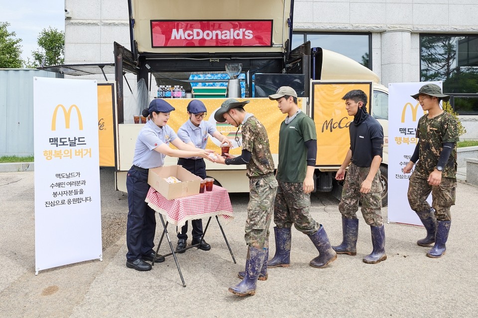 가평 지역 수해 복구에 참여한 군 장병들이 맥카페 음료트럭 앞에서 버거와 음료를 수령하고 있다. (사진=한국맥도날드)