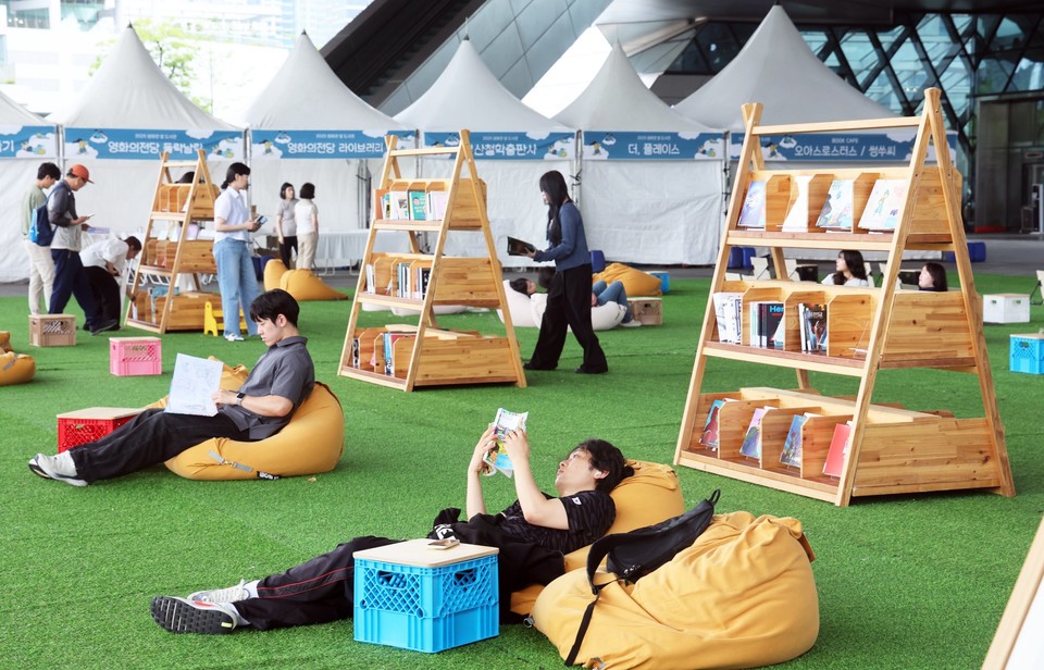 문체부가 한국출판문화산업진흥원과 함께 오는 26일부터 28일까지 서울 광진구 서울어린이대공원 포시즌 가든과 팔각당 전시실에서 '독서는 여행, 북클럽은 동행'을 주제로 '2025 책 읽는 대한민국'을 처음으로 개최한다. 사진은 부산 해운대구 영화의전당 야외광장에서 열린 '영화관 옆 도서관' 행사에서 시민이 소파에 누워 책을 읽고 있는 모습. (사진=연합뉴스)